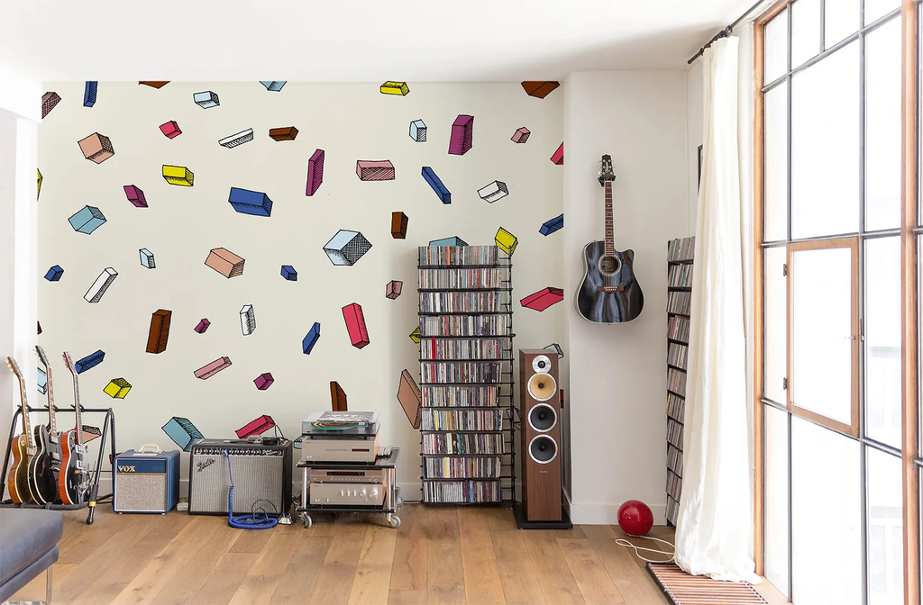 A lively room featuring a Tetris, Pattern Wallpaper in Multicolor, filled with shapes resembling game pieces. The room is complemented by various musical instruments and a bookshelf.