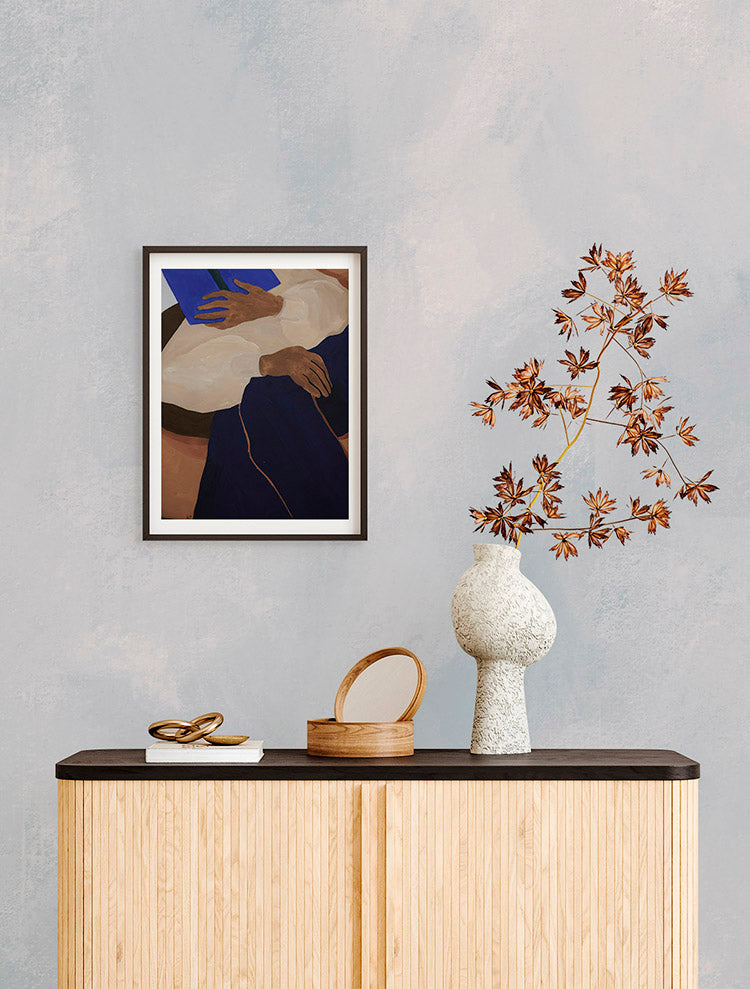 The room features Addison Chalk, Ombre Wallpaper in Blue. A wooden console table holds a framed abstract artwork, a reddish-leaved plant, and decorative objects. The overall ambiance is modern and stylish.
