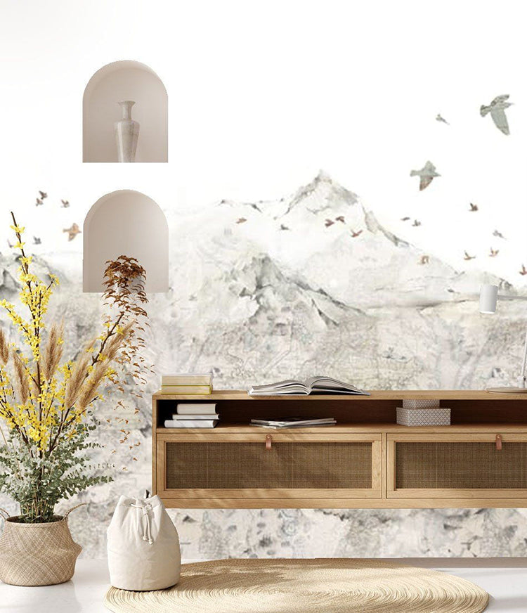 Danone Mountain Landscape Wallpaper showcasing a tranquil scene of a detailed mountain range with birds in flight, creating a serene ambiance in an indoor setting, above a wooden console table adorned with books and decorative items.