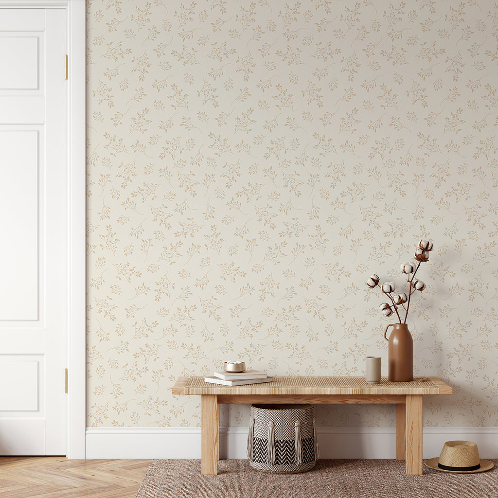 A serene room with a wooden bench, a vase with branches, a cup, a woven basket, and a hat on the floor. Delicate Foliages, Pattern Wallpaper in Nude adorns the walls.