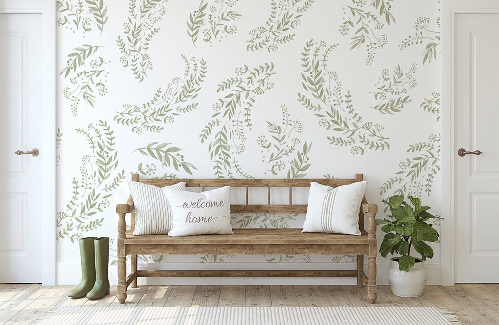 A welcoming entryway with rustic charm, featuring a wooden bench with ‘welcome home’ cushion, green boots, and a potted plant, set against Flower Fields, Floral Patten Wallpaper in Green.