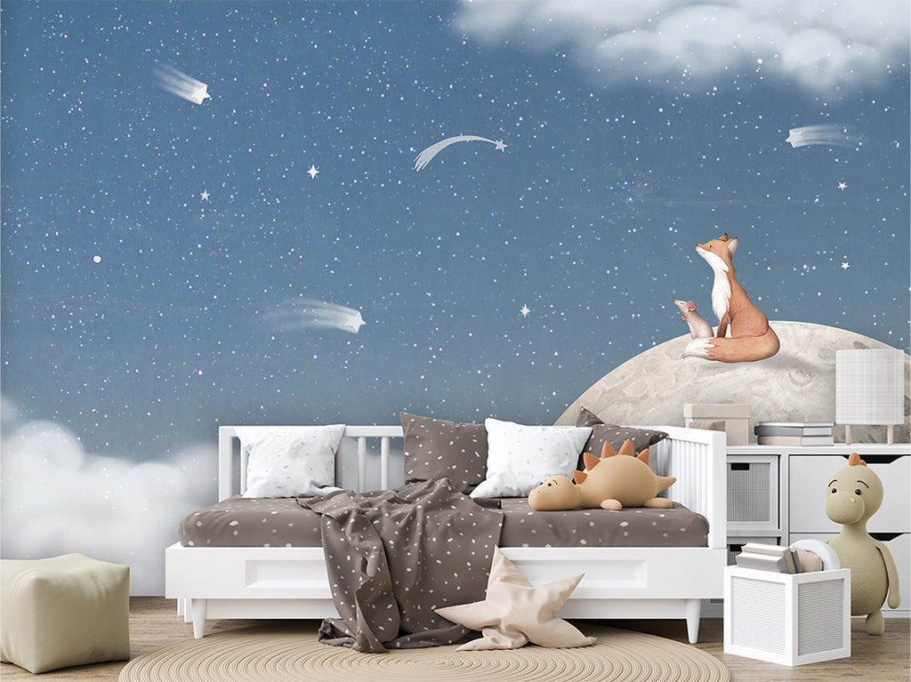 A captivating bedroom scene featuring the Fox on the Moon, Mural Wallpaper in Blue. The mural depicts a whimsical fox sitting atop a moon amidst a starry sky and fluffy clouds, creating an enchanting atmosphere in the room. the bedroom has a white framed bed with white, and brown sheets and pillows, and is surrounded by plush animals and toys. 