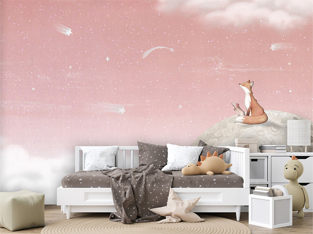 A captivating bedroom scene featuring the Fox on the Moon, Mural Wallpaper in Pink. The mural depicts a whimsical fox sitting atop a moon amidst a starry sky and fluffy clouds, creating an enchanting atmosphere in the room. the bedroom has a white framed bed with white, and brown sheets and pillows, and is surrounded by plush animals and toys. 