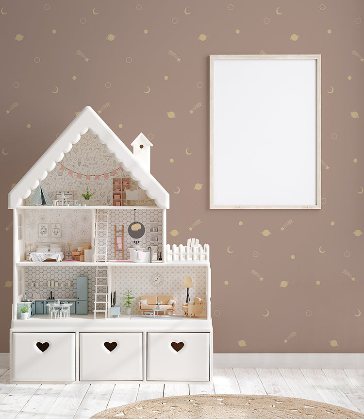 A child's room featuring a large white dollhouse with heart-shaped drawer handles, set against a wall adorned with the Gold Metallic Space Galaxy, Wallpaper in Pink. A blank picture frame hangs on the wall, awaiting a personalized touch.