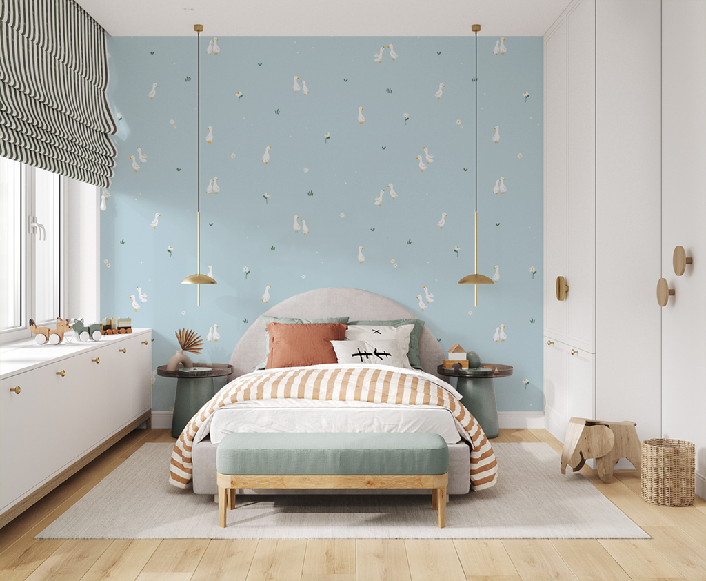 Bedroom with blue Graceful Geese wallpaper, gray bed, striped bedding, pendant lights, wooden accents, and playful decor.