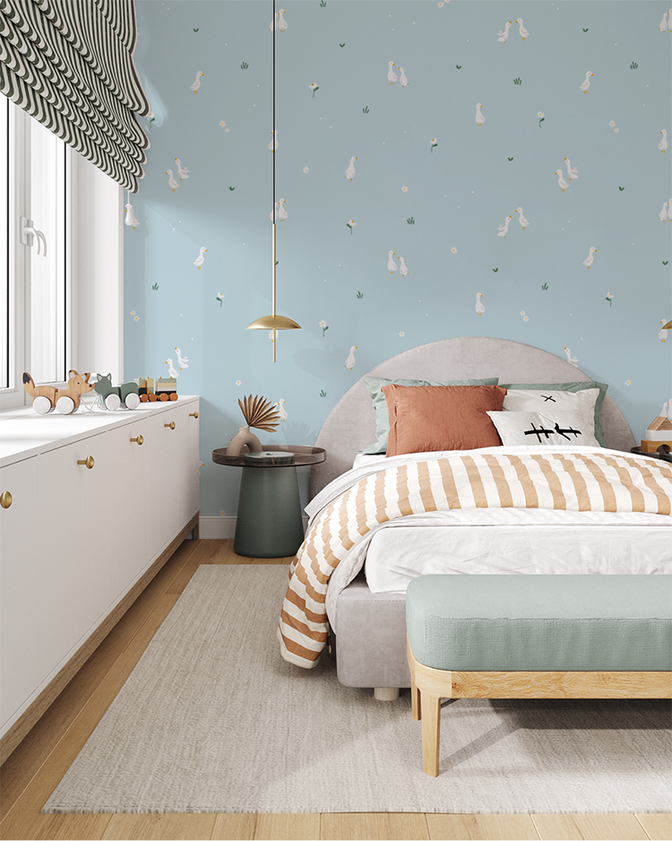 Bedroom with blue Graceful Geese wallpaper, gray bed, striped bedding, pendant lights, wooden accents, and playful decor.