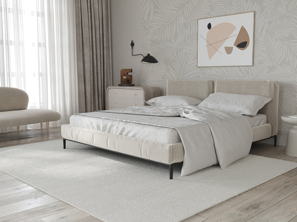 Modern bedroom with Heather Fern, Pattern Wallpaper in Light Grey, featuring a serene botanical design. Includes a white bed, beige armchair, cream rug, and abstract wall art.