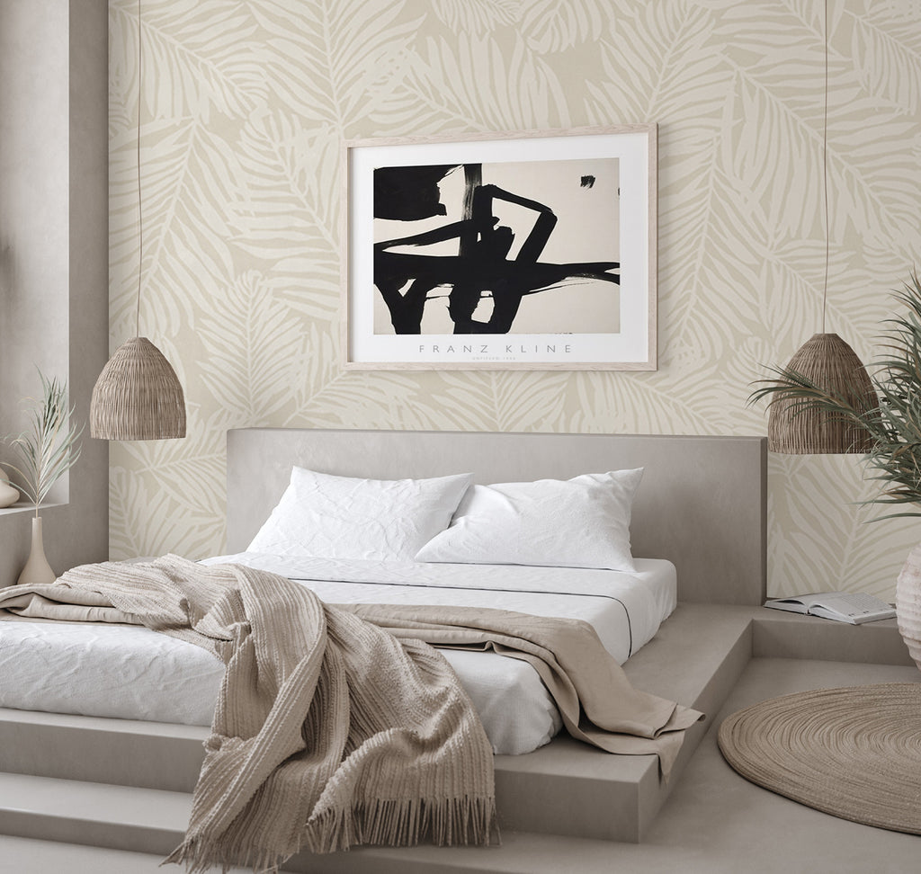 Modern bedroom with Heather Fern, Pattern Wallpaper in Sand, featuring leaf designs. Decor includes a Franz Kline abstract artwork, wicker lamps, and a cozy beige bed throw.