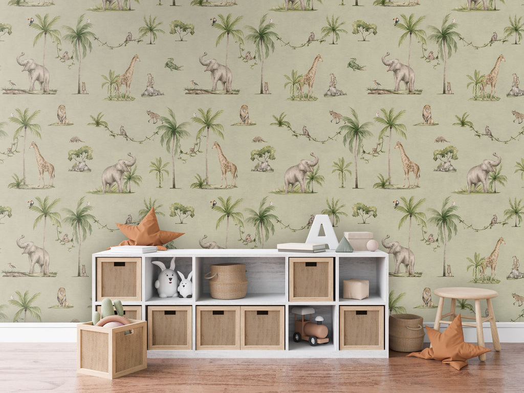 Joyful Jungle, Pattern Wallpaper in a green, the room includes a white storage unit with woven baskets, a star-shaped cushion, a letter 'A,' and some books. Additionally, there is a wooden stool with another star-shaped cushion and a basket of toys on the floor. The room has a cozy wooden floor.