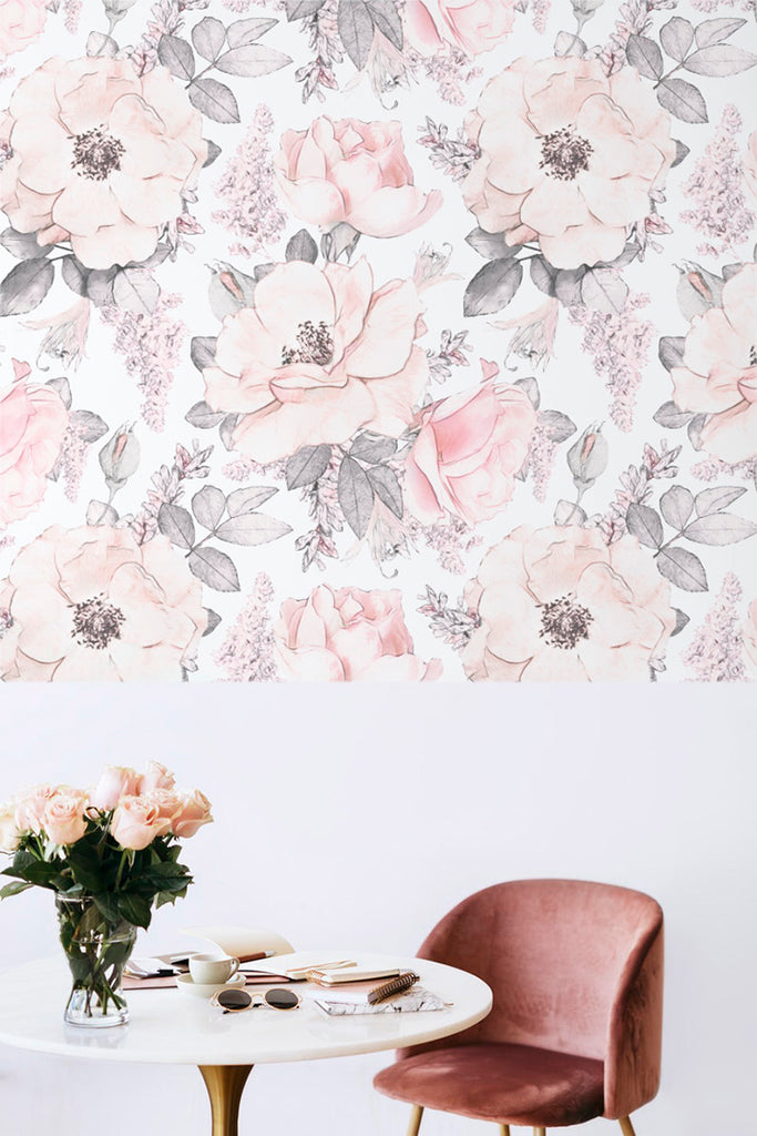 Elegant Kiela Flowers Pattern Wallpaper in soft pink and white blooms with gray foliage on a light background, enhancing a chic interior with a pink chair and table set.
