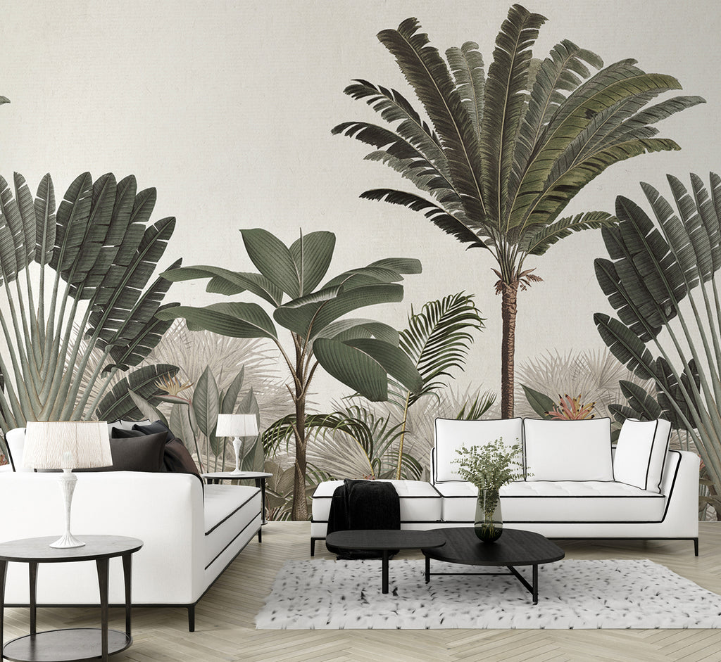 A chic living room with Palm Paradise, Tropical Mural Wallpaper in Green, featuring large palm leaf prints. The decor is complemented by a white sofa, black armchair, glass side table, and a patterned rug.
