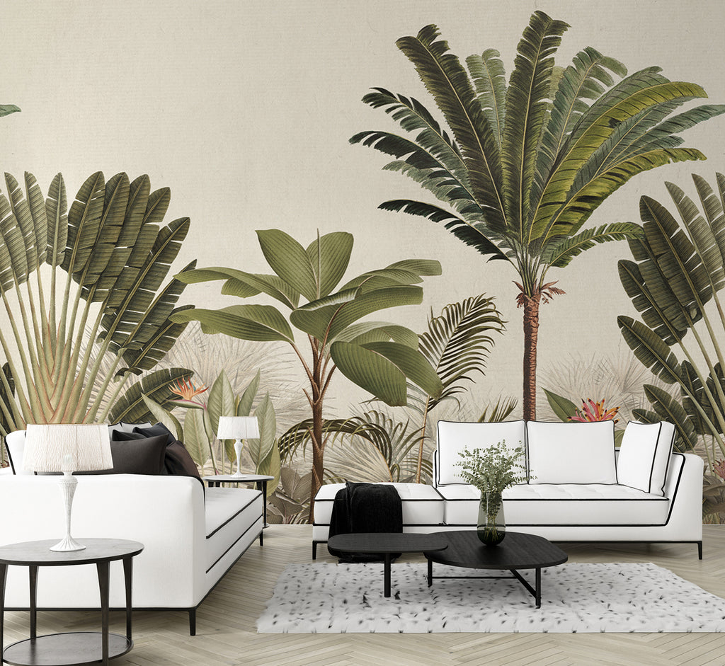 A chic living room with Palm Paradise, Tropical Mural Wallpaper in Honey, featuring large palm leaf prints. The decor is complemented by a white sofa, black armchair, glass side table, and a patterned rug.