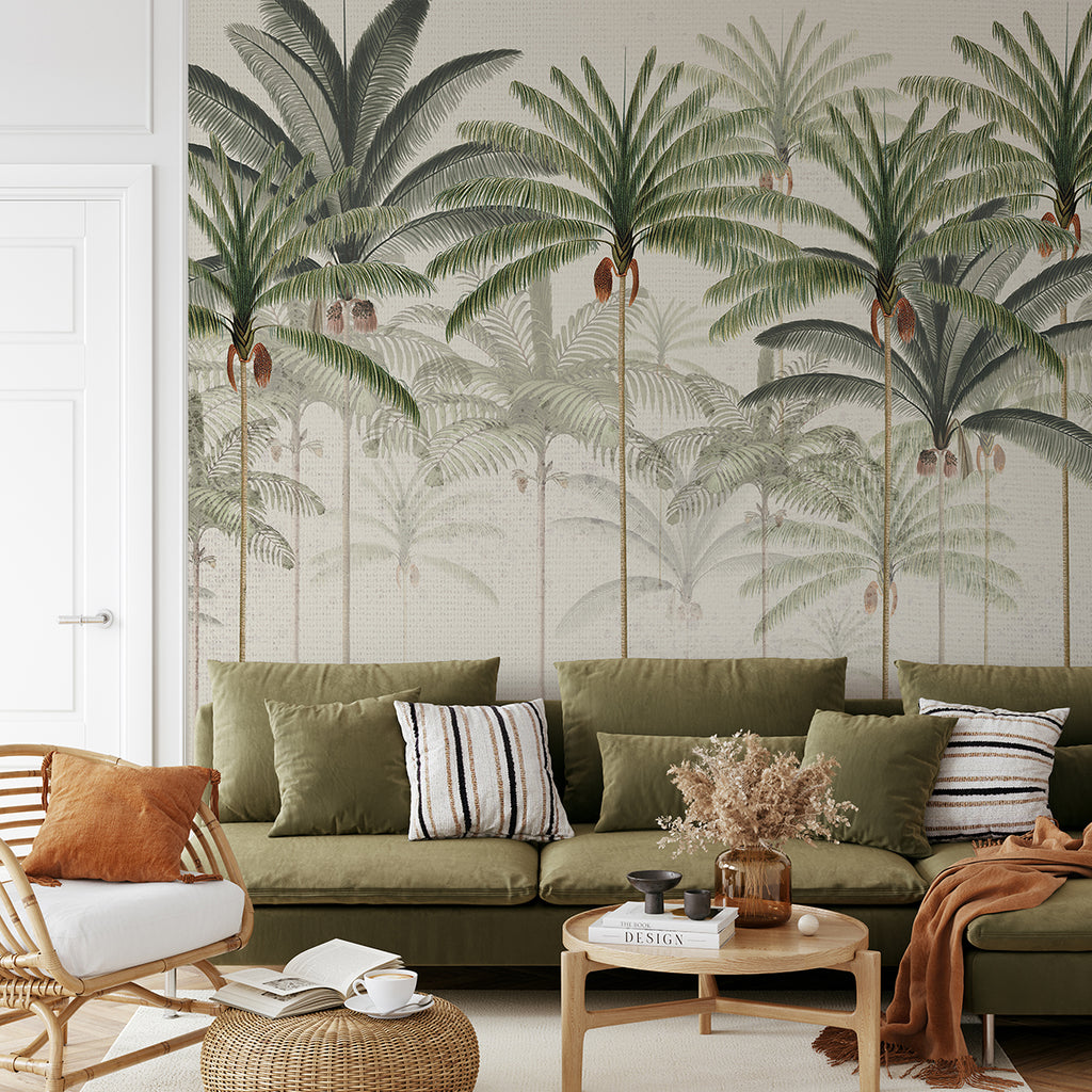 A tastefully decorated room, featuring a Rainforest Vintage, Mural Wallpaper in Honey . The room is adorned with a plush green sofa, a wooden chair, and a round coffee table. The wallpaper adds a touch of nature with its large palm leaves.
