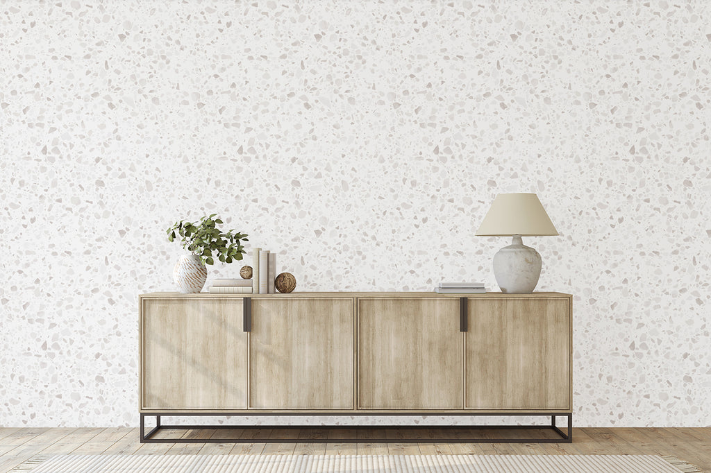 Minimalist room featuring Terrazzo Blanc, Faux Texture Wallpaper, a wooden sideboard with a lamp, a plant in a vase, and decorative items, creating a modern and elegant space.