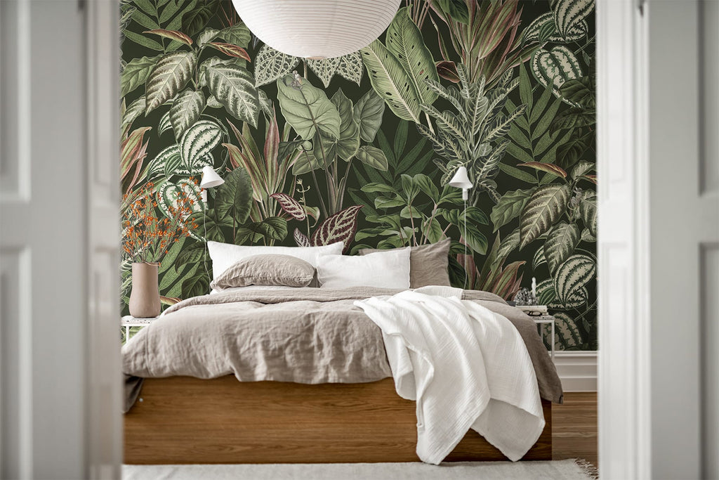 Night-time Jungle, Tropical Mural Wallpaper in forest green featured on a wall of a bedroom with a bed with white and light brown sheets