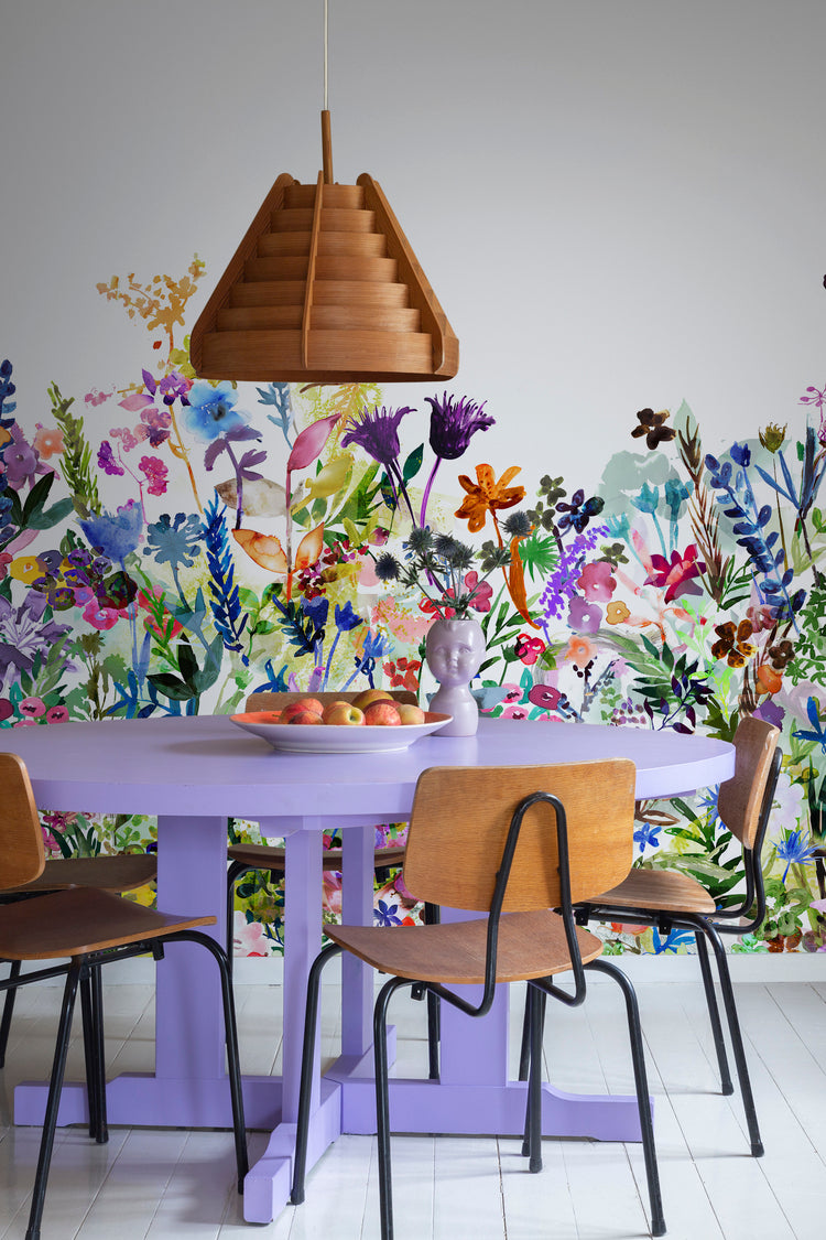 HC-May_Meadows_Floral_Mural_Wallpaper-MulticolorBright-Interior1-18122023.jpg May Meadow, Floral Mural Wallpaper in multicolor bright featured on a wall of a dining area with violet round table and wooden chair