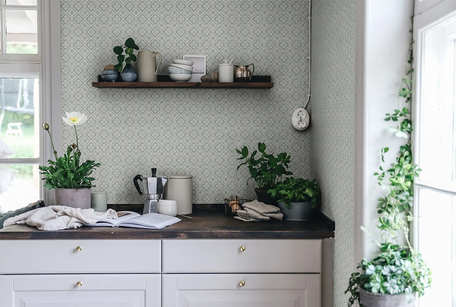 Edvin Rhombus Patterned Wallpaper in sage featured on a wall of a kitchen with a wooden countertop