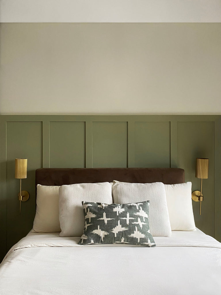 Bedroom with white bedding and olive green panelling