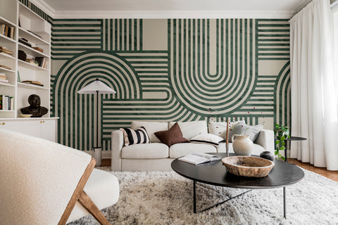 Stella Arch, Geometric Mural Wallpaper in green featured on the wall of a living area with coffee table and sofa
