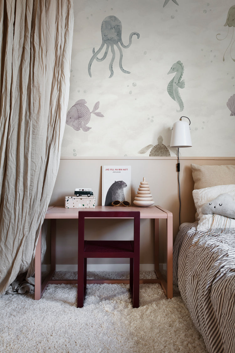 Ocean Friends, Pattern Wallpaper in sand featured on a wall of a bedroom with fluffy floor mat and a comfortable bed and patterned bed sheets
