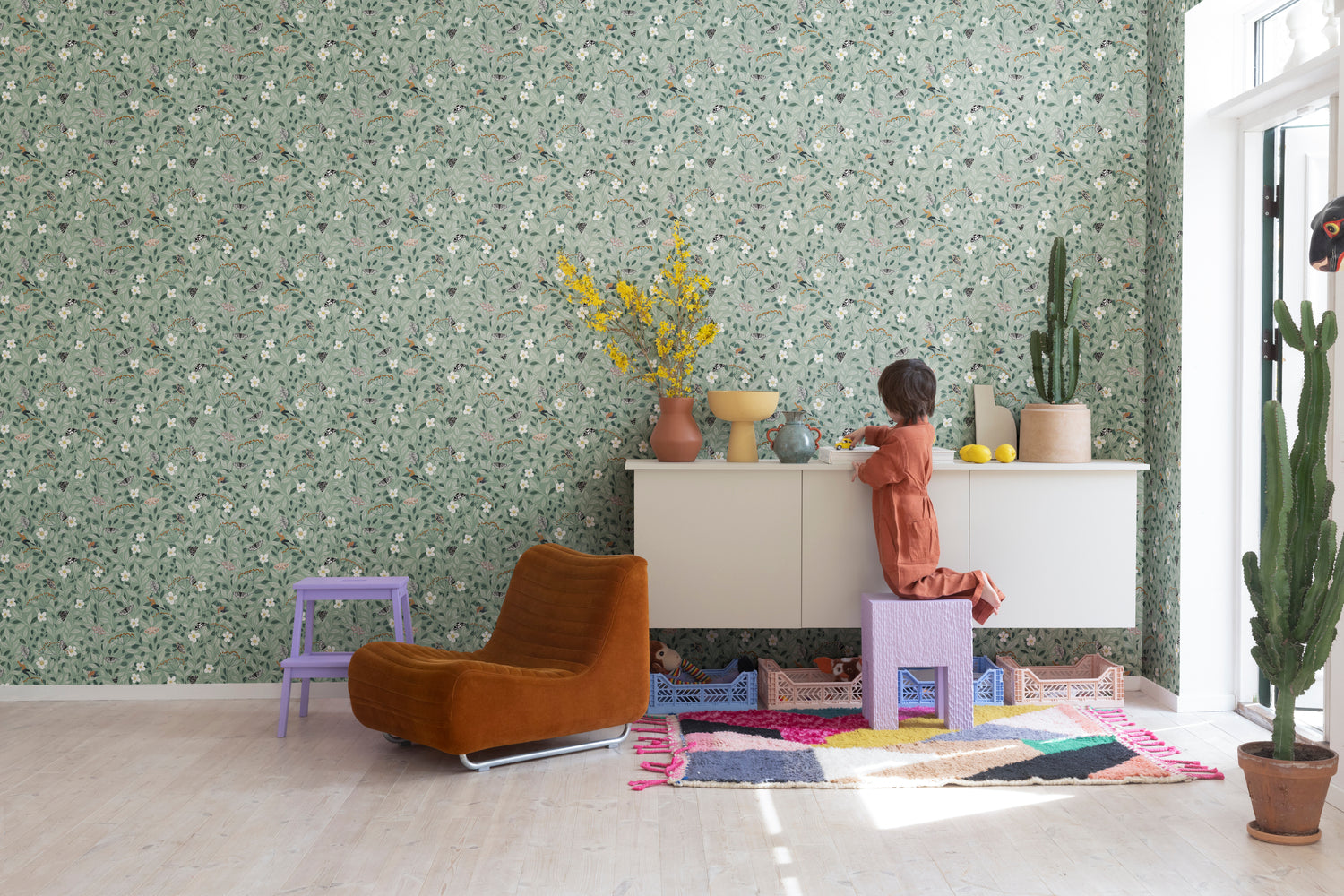 HC-Pixie_Floral_Pattern_Wallpaper-Green-Interior2-01122023.jpg Pixie, Floral Pattern Wallpaper in kids bedroom with terracotta cushion and vase