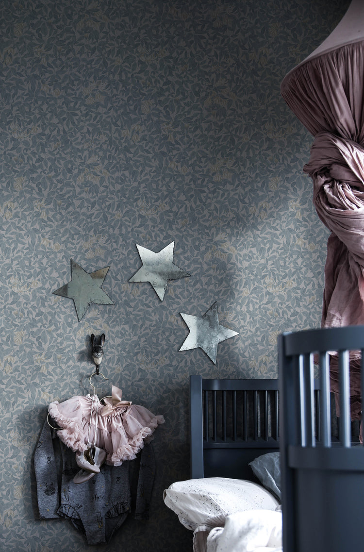 Linnea, Floral Pattern Wallpaper in blue featured on a wall of a kid’s room with grey crib and stars on the wall