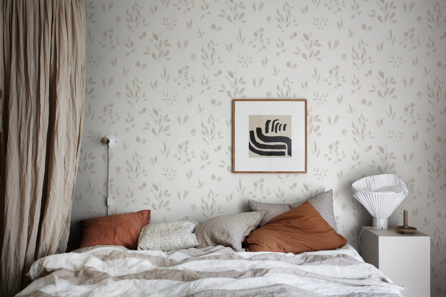 Belle Foliages, Tropical Pattern Wallpaper in Sand featured on a wall bedroom with multiple colored pillows and a patterned bedsheet