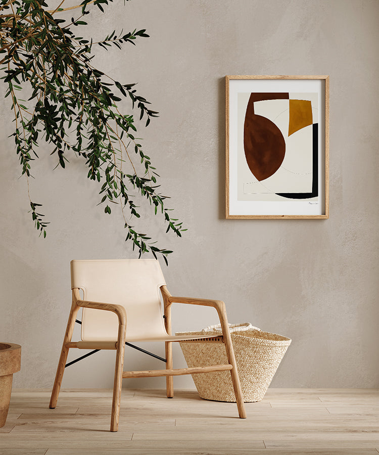 A contemporary room adorned with Addison Chalk, Ombre Wallpaper in Sand, sets a tranquil mood. A modern beige armchair, a woven basket, and a framed abstract artwork add elegance. The room’s minimalist design, complemented by a touch of greenery, exudes a serene and inviting atmosphere.