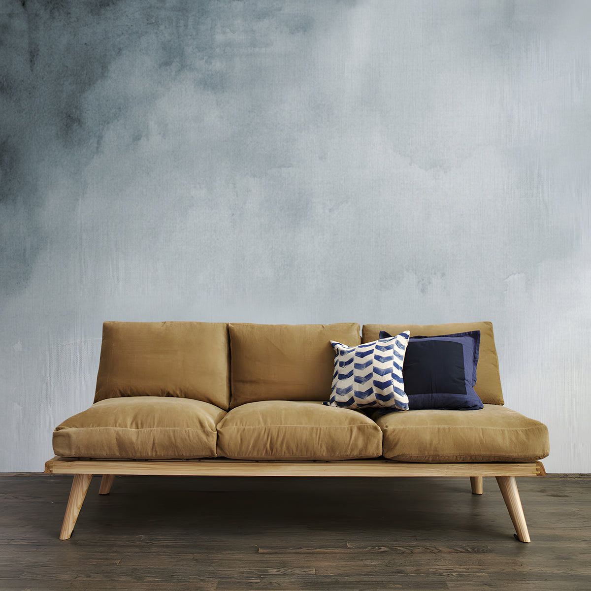 Aista, Ombre Watercolour Wallpaper in grey featured in a room with wooden sofa and brown cushion