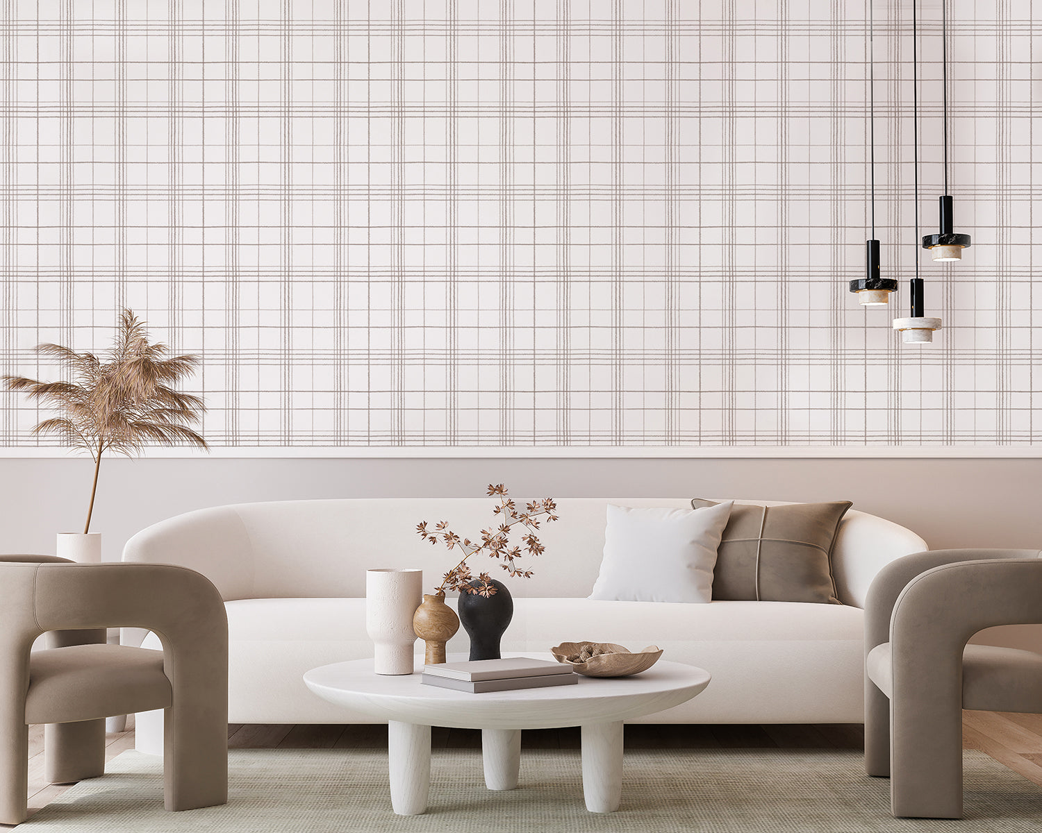A modern living room featuring a white sofa with a grey cushion, a round table with decorative vases and a book, all set against a backdrop of Hand-Drawn Plaids, Pattern Wallpaper in Brown