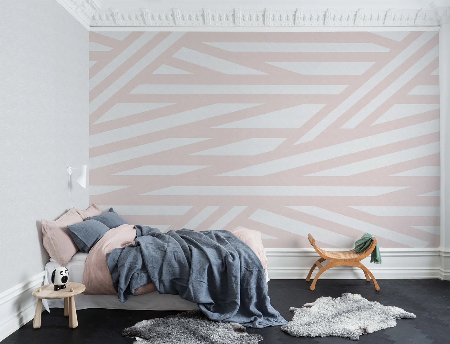 Sailor's Sea, Striped Wallpaper in Blush Pink as seen on the wall of a bedroom with grey floor mats and bed with dark blue bed sheets and pink pillows that matches its aesthetics