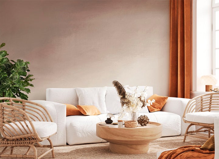 Living room with rattan furnishings and blush pink ombre wallpaper
